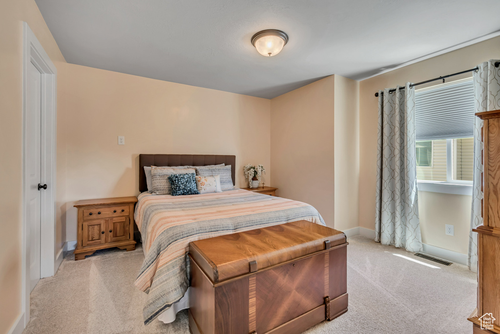 Bedroom with light colored carpet and baseboards