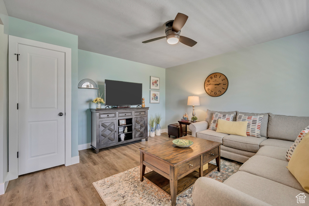 Living area featuring ceiling fan, light wood-type flooring, and baseboards