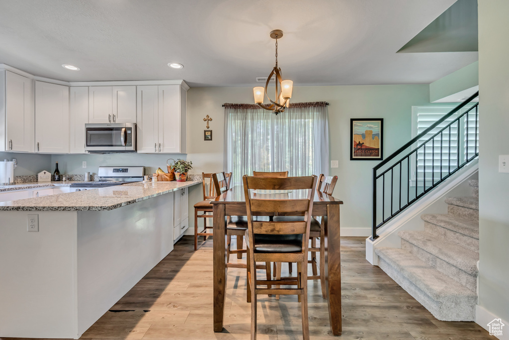 Dining room featuring stairway, healthy amount of natural light, recessed lighting, and light wood-style floors