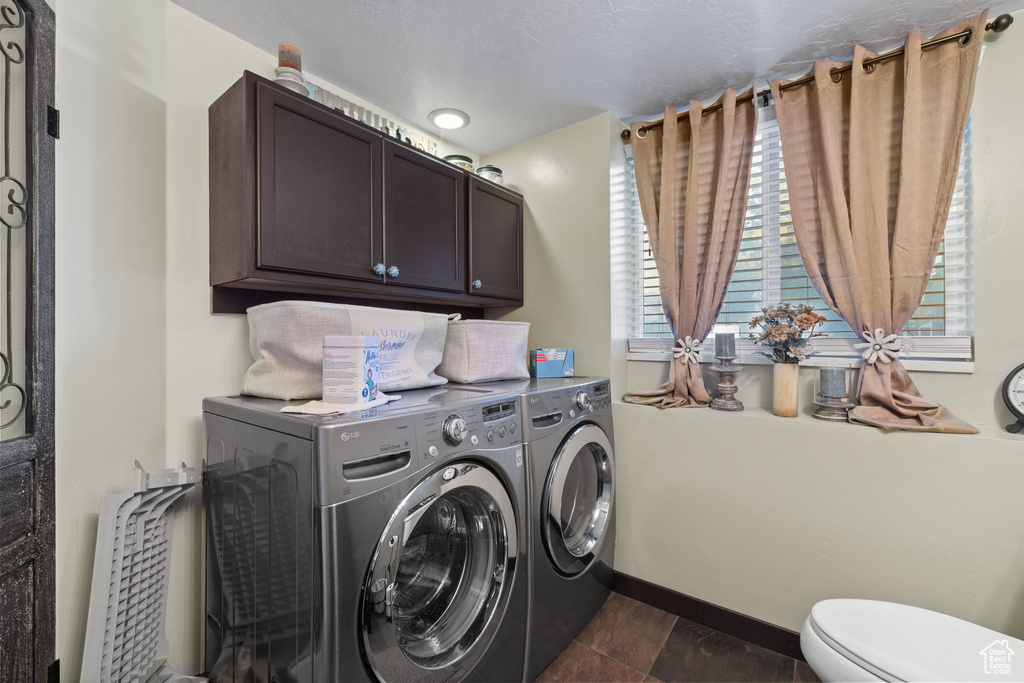 Washroom with washer and clothes dryer and baseboards
