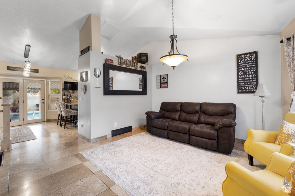 Tiled living room with lofted ceiling and baseboards
