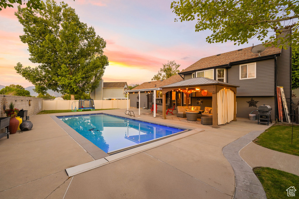 View of pool with an outdoor living space, a gazebo, a patio area, and a fenced backyard