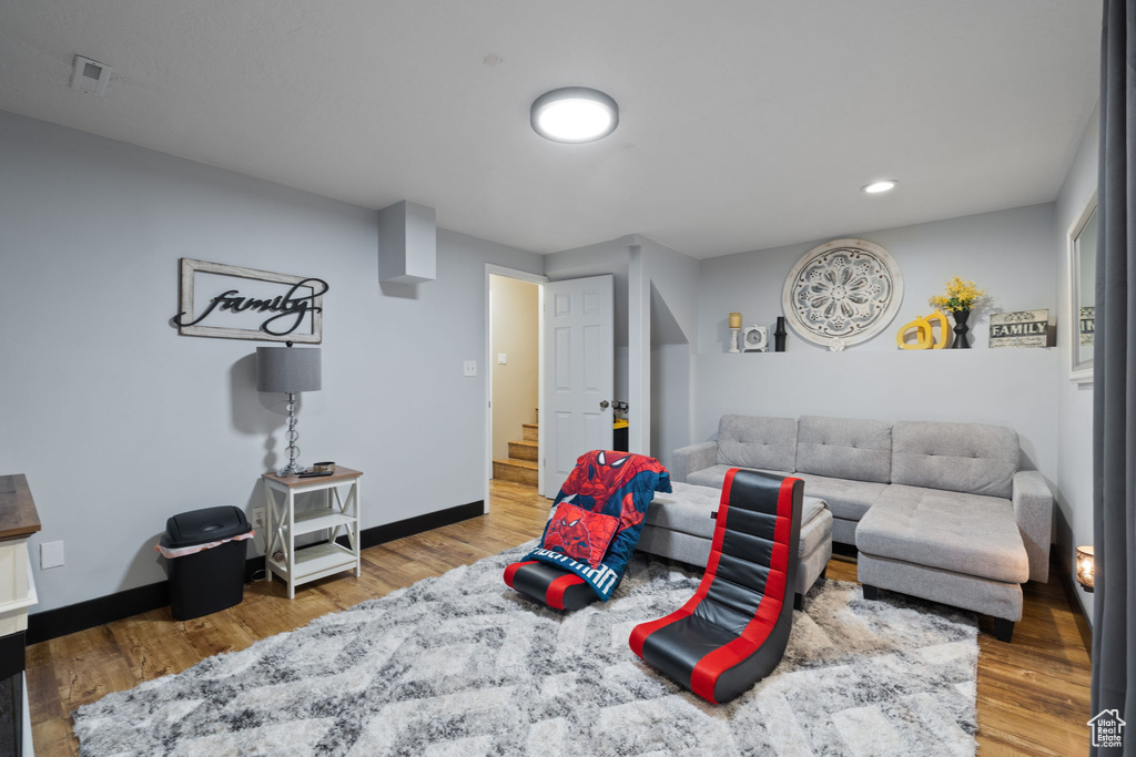 Living area with stairs, wood finished floors, baseboards, and recessed lighting