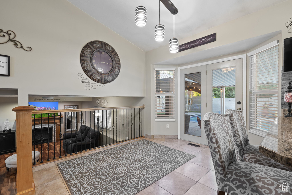 Tiled entryway featuring a high ceiling, a fireplace, and baseboards