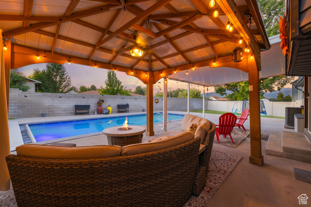 View of pool featuring a fire pit, a gazebo, a patio, and a fenced backyard