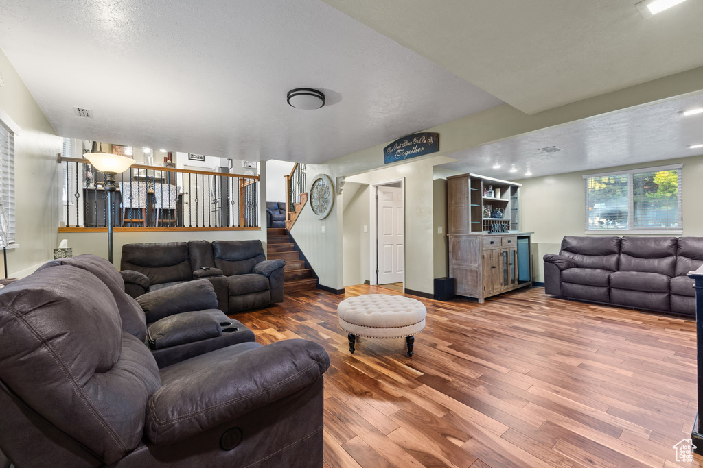 Living area featuring a dry bar, stairs, and wood finished floors