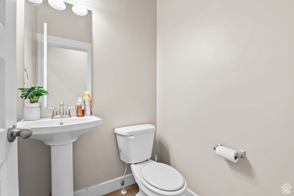 Half bath with baseboards and toilet