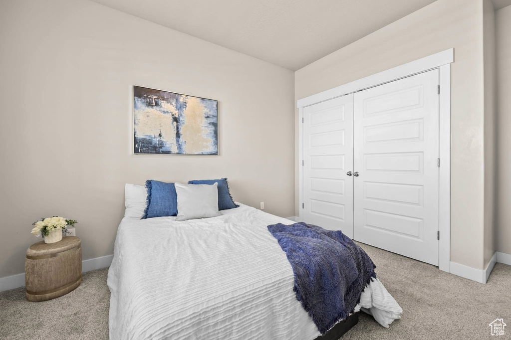 Carpeted bedroom with baseboards and a closet