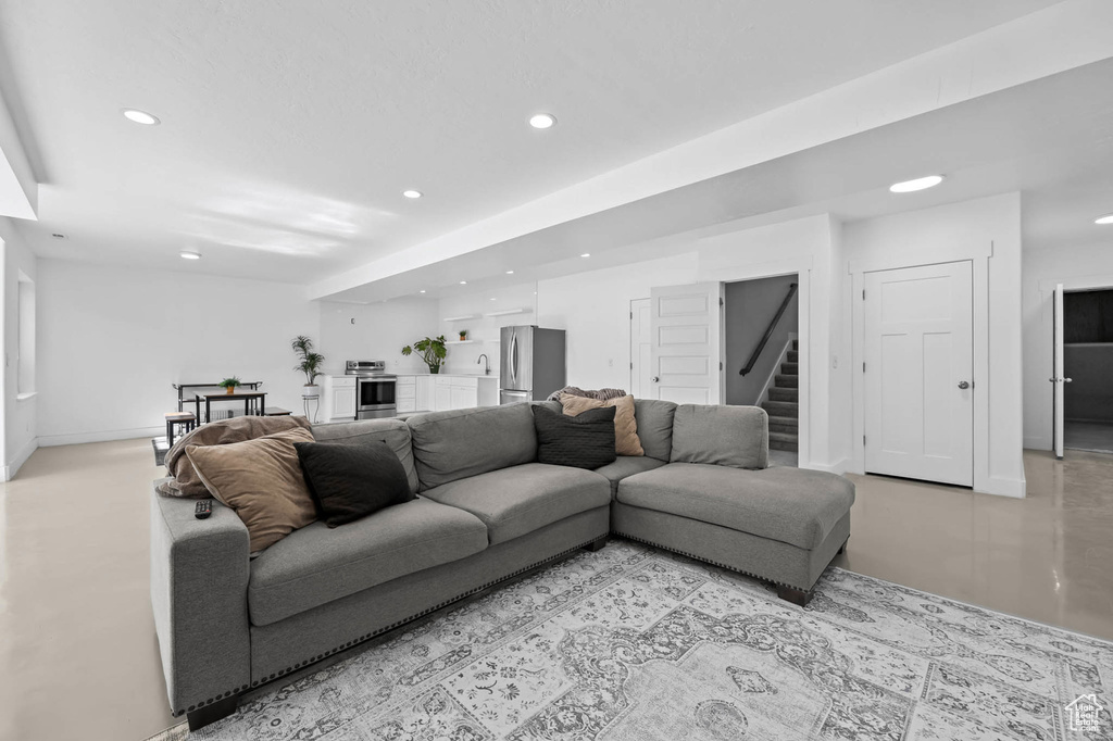 Living area with recessed lighting, stairs, and baseboards
