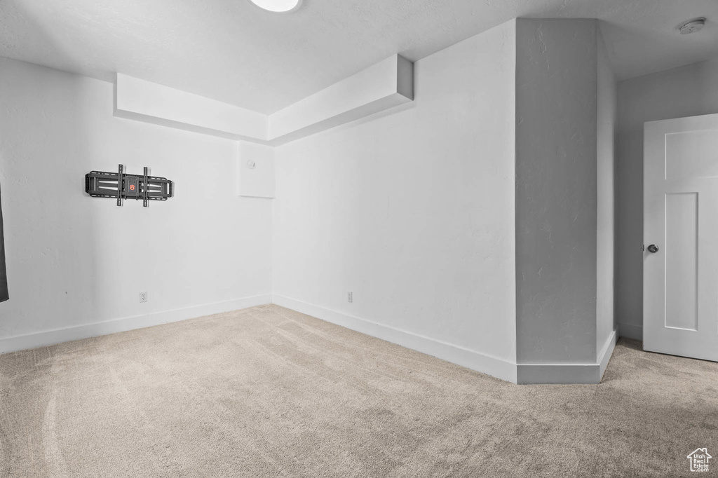 Unfurnished room with carpet floors, baseboards, and a smoke detector