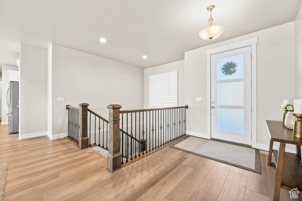 Foyer entrance with light wood-style flooring, baseboards, and recessed lighting