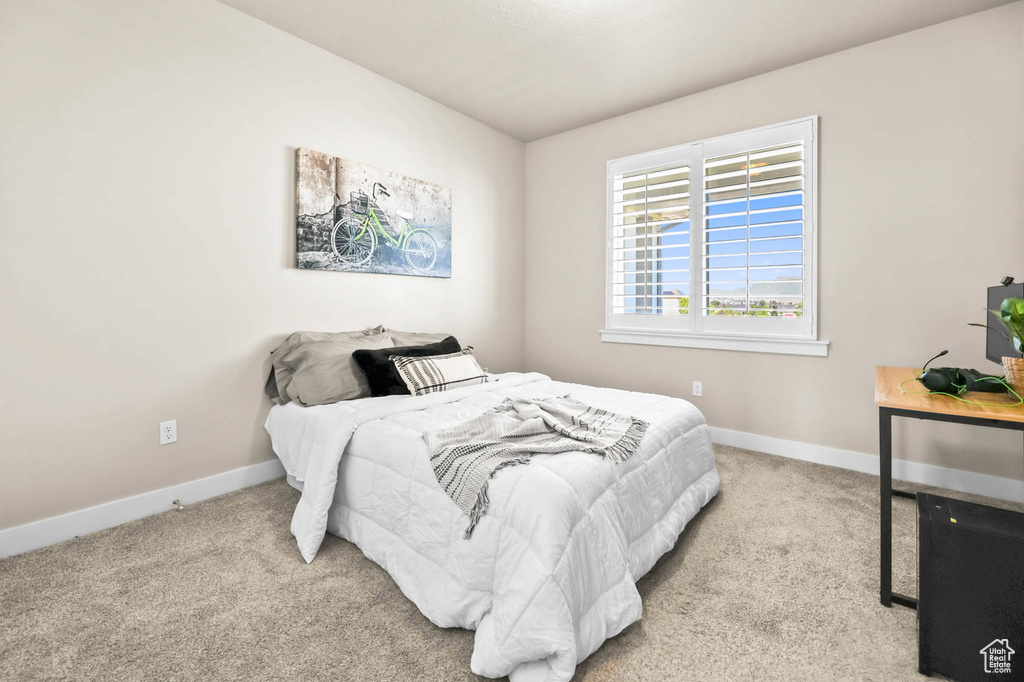 Bedroom featuring carpet, baseboards, and vaulted ceiling