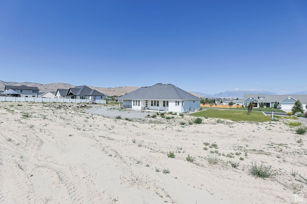 Back of property with a mountain view and a residential view