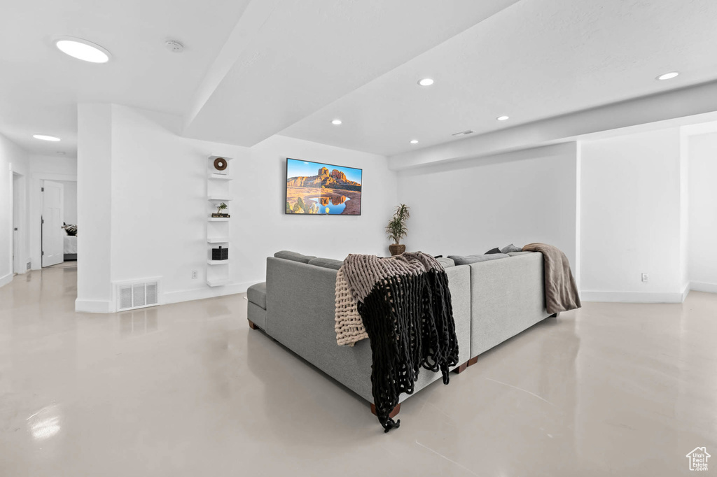 Living area with recessed lighting, finished concrete floors, and baseboards