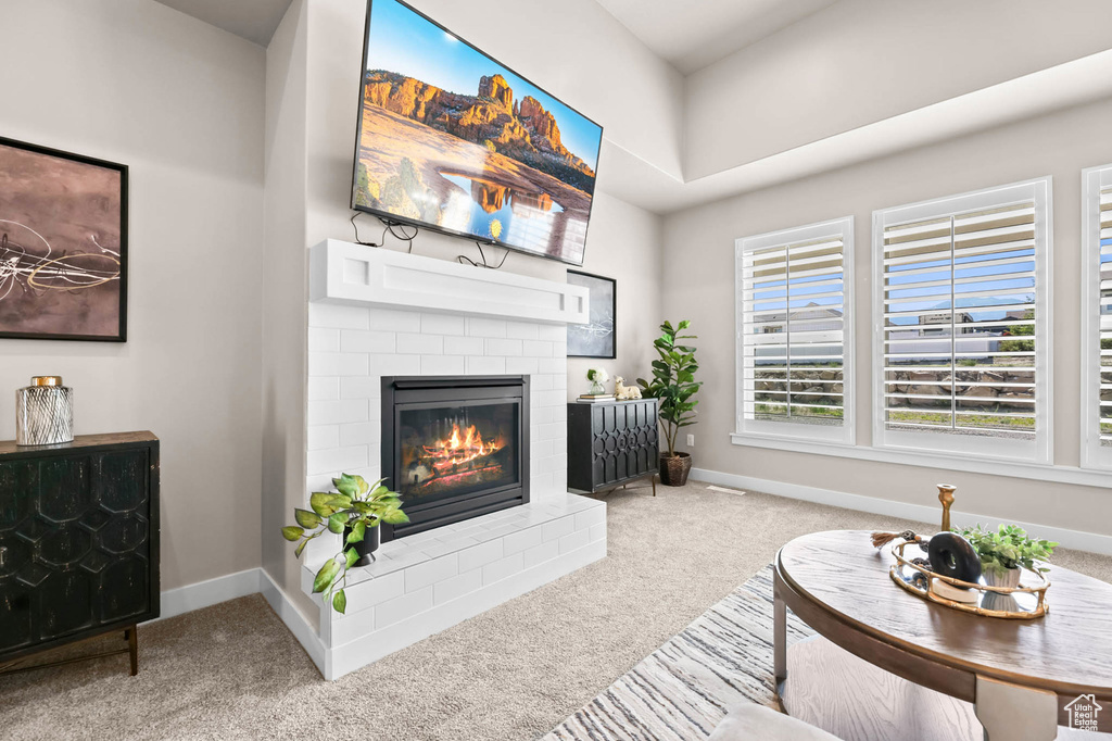 Carpeted living room with a fireplace and baseboards