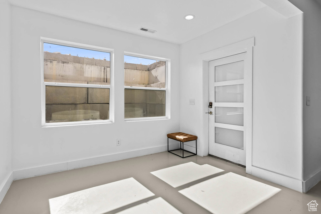 Foyer entrance with recessed lighting and baseboards