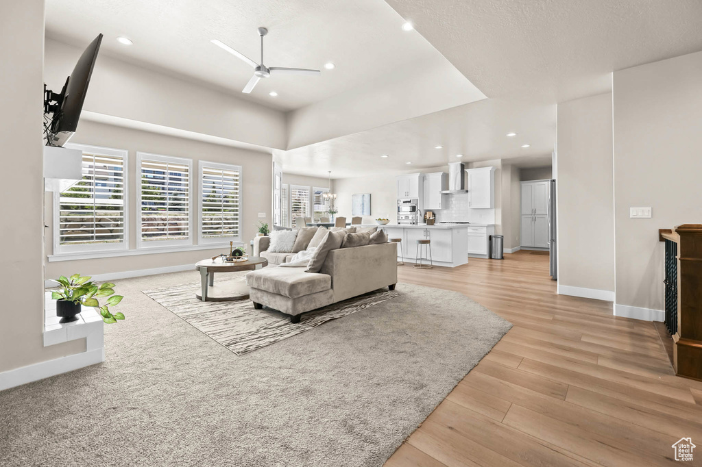 Living room featuring ceiling fan, baseboards, recessed lighting, and light wood-style flooring