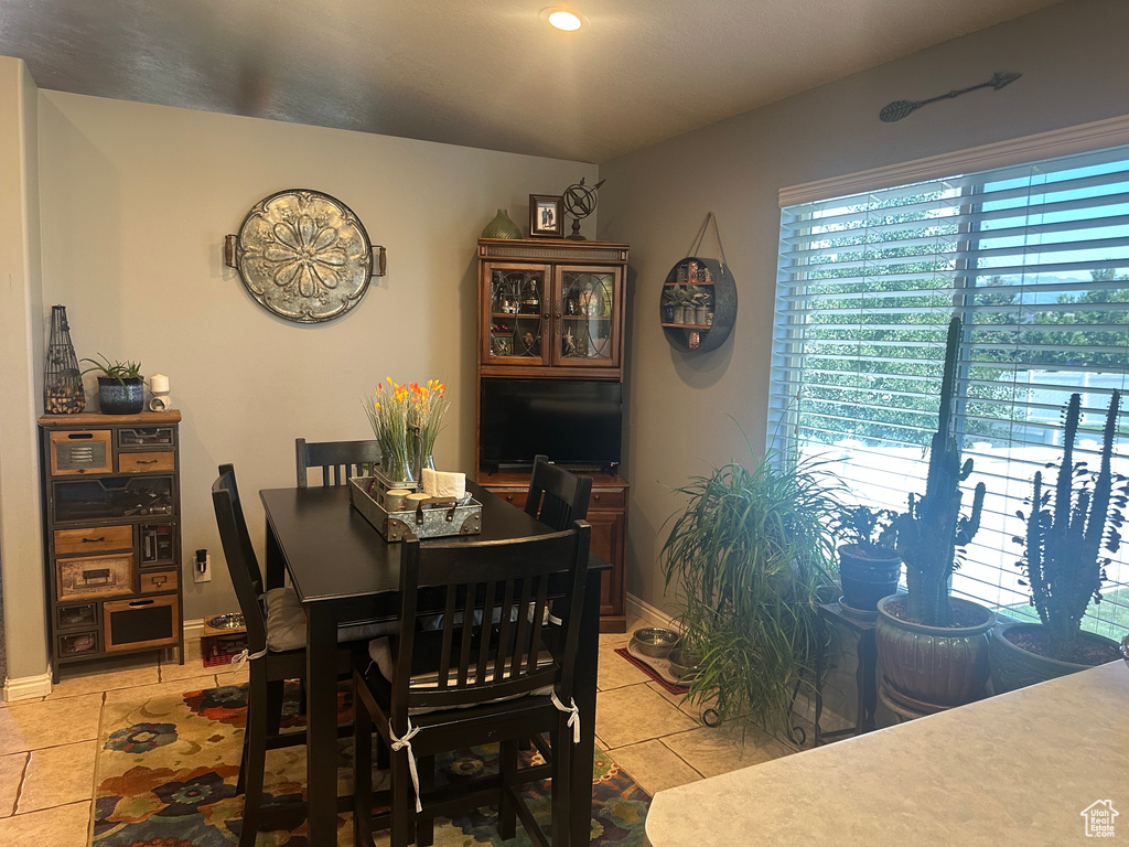 Dining room with light tile patterned floors, baseboards, and recessed lighting