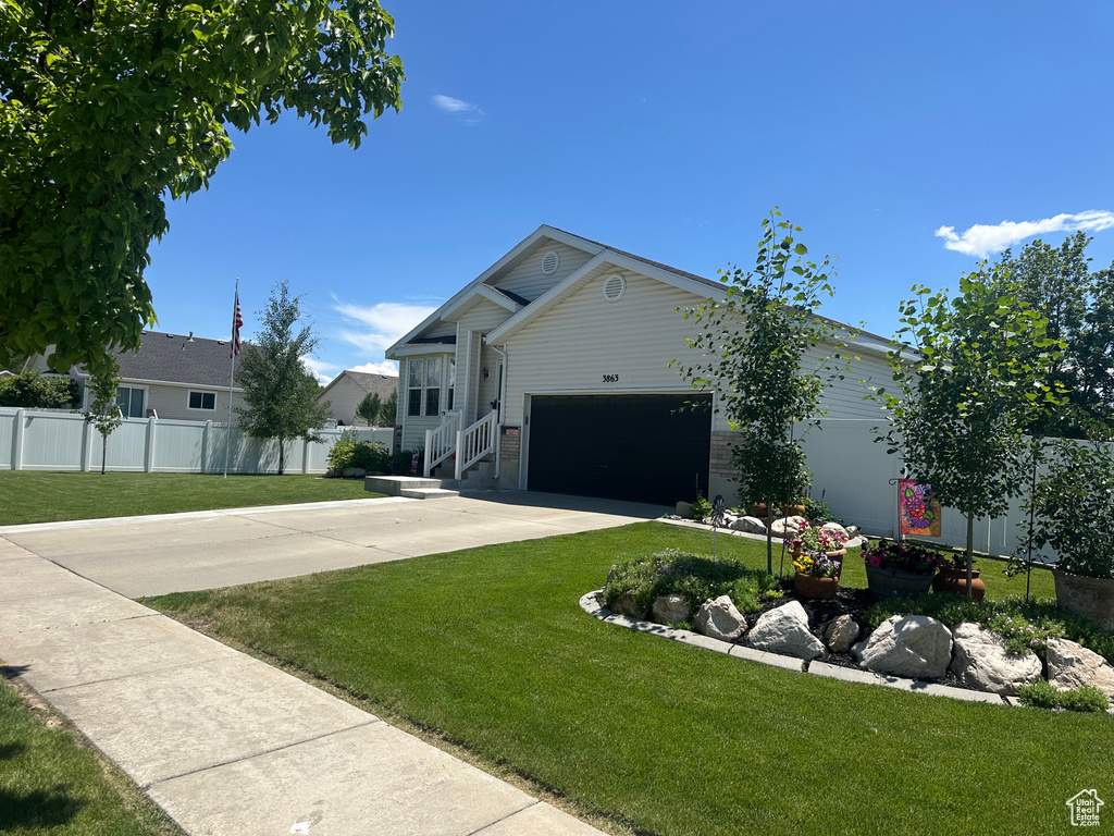 View of front of home with a garage and driveway