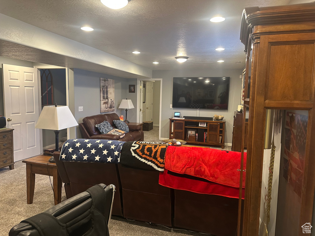 Carpeted living area featuring recessed lighting and baseboards