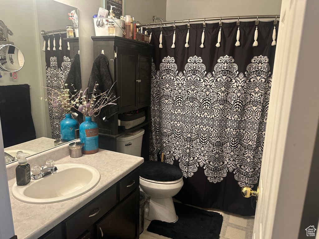 Bathroom with vanity, toilet, and a shower with curtain