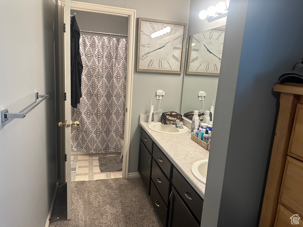 Bathroom with double vanity and a shower with shower curtain