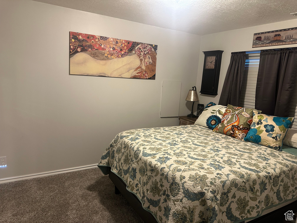 Carpeted bedroom with a textured ceiling and baseboards