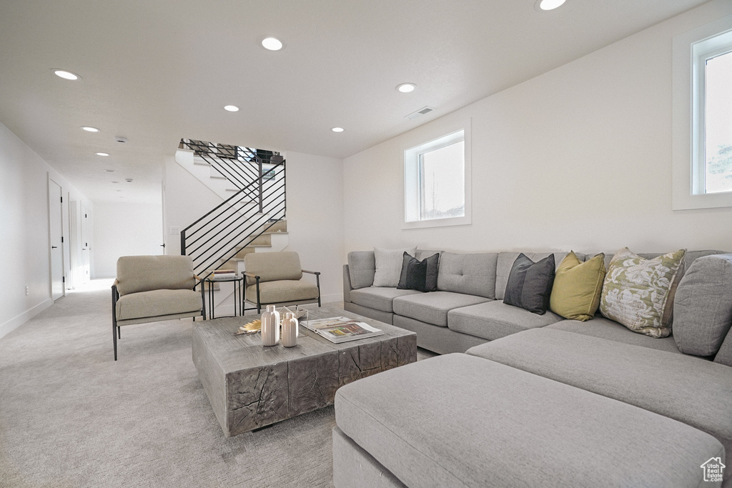 Living room with recessed lighting, stairway, light colored carpet, and baseboards