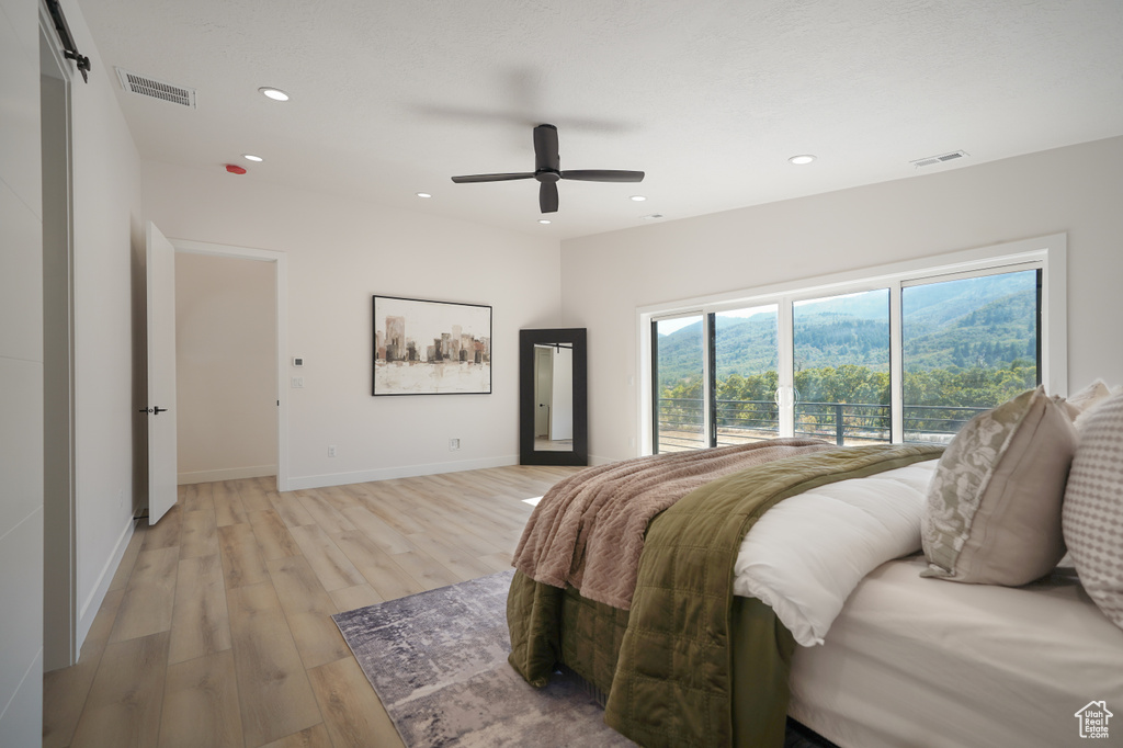 Bedroom with light wood finished floors, recessed lighting, baseboards, ceiling fan, and access to exterior
