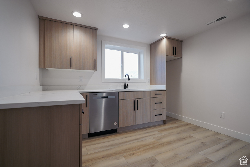 Kitchen featuring dishwasher, a sink, recessed lighting, light wood-type flooring, and baseboards