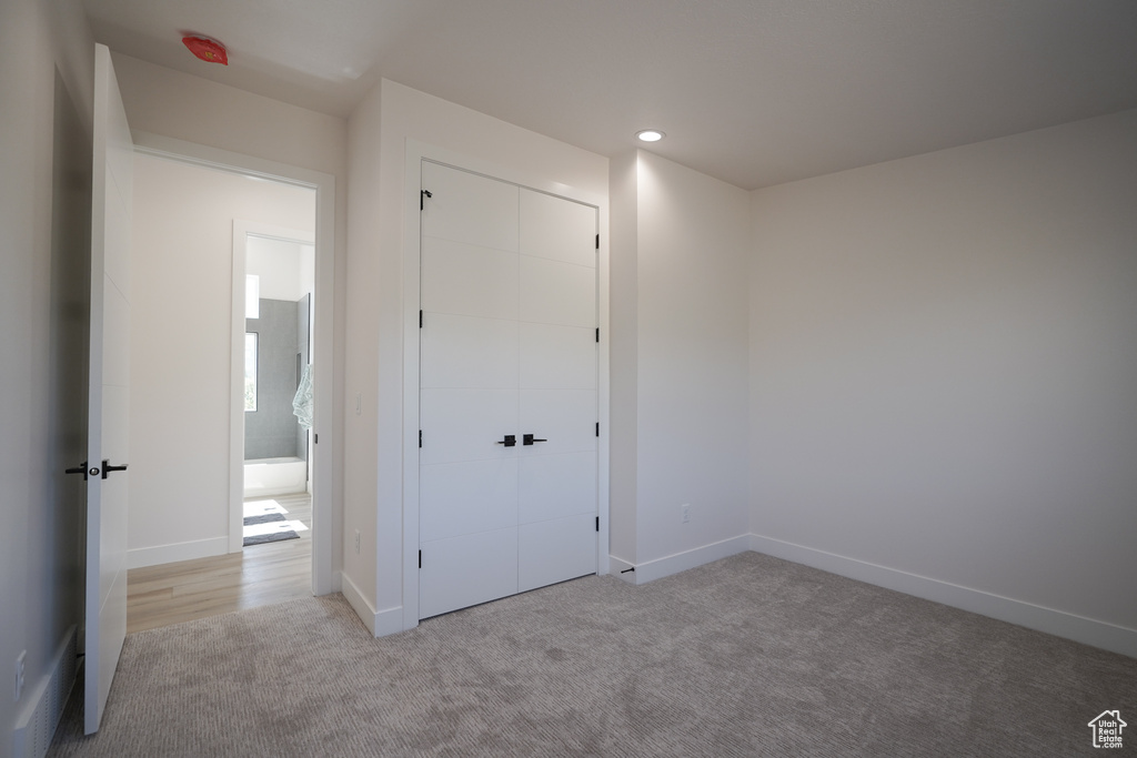 Unfurnished bedroom with carpet floors, a closet, baseboards, and recessed lighting