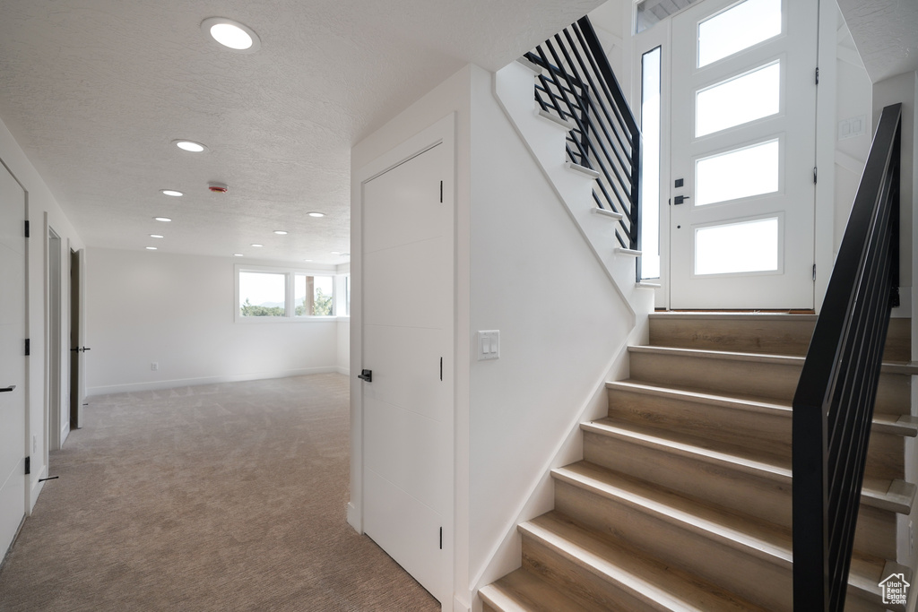 Stairs with recessed lighting, carpet, and baseboards
