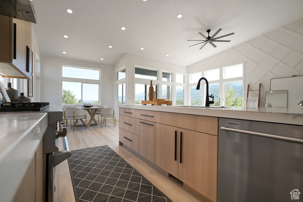 Kitchen with stainless steel dishwasher, modern cabinets, light brown cabinets, light countertops, and recessed lighting