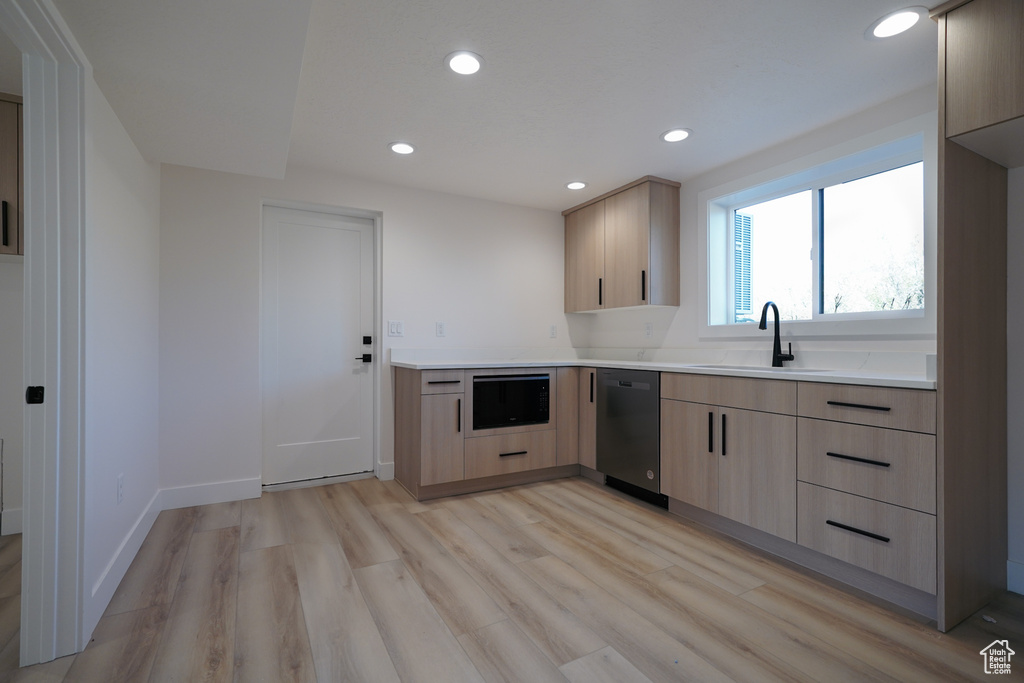 Kitchen with a sink, light brown cabinets, dishwasher, light wood-style flooring, and recessed lighting