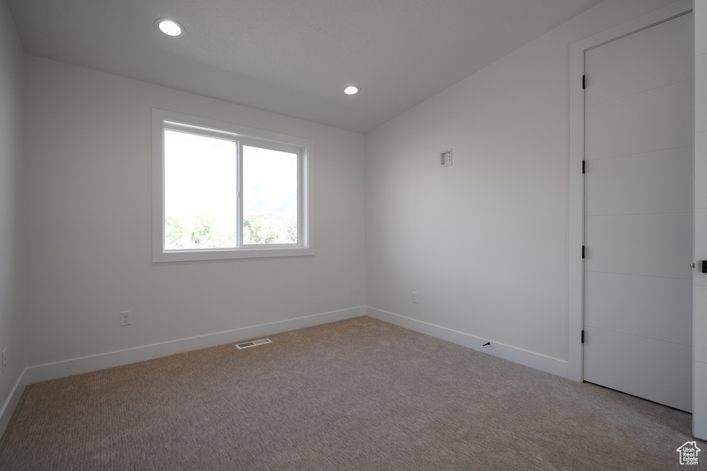Carpeted empty room with baseboards and recessed lighting