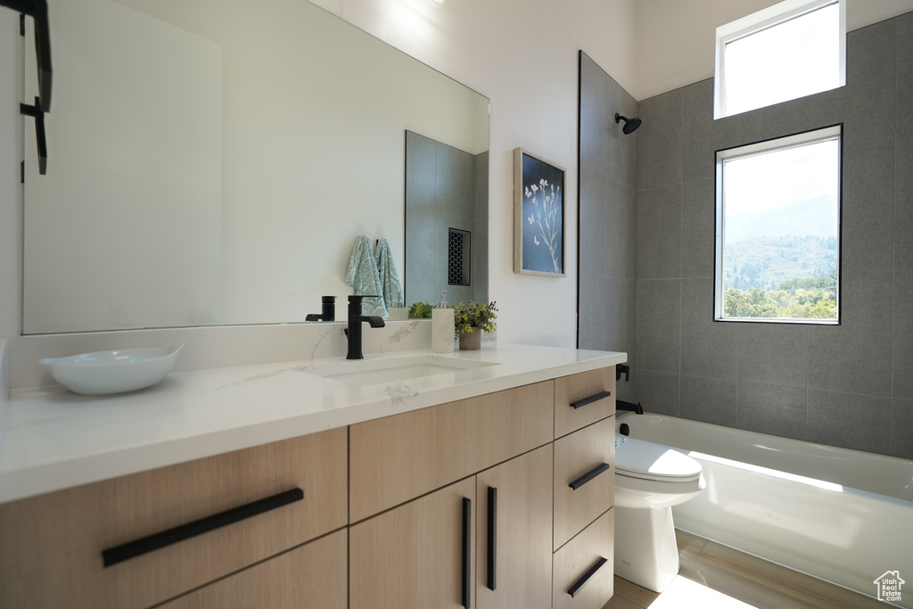 Full bath with toilet, vanity, shower / bathtub combination, and wood finished floors