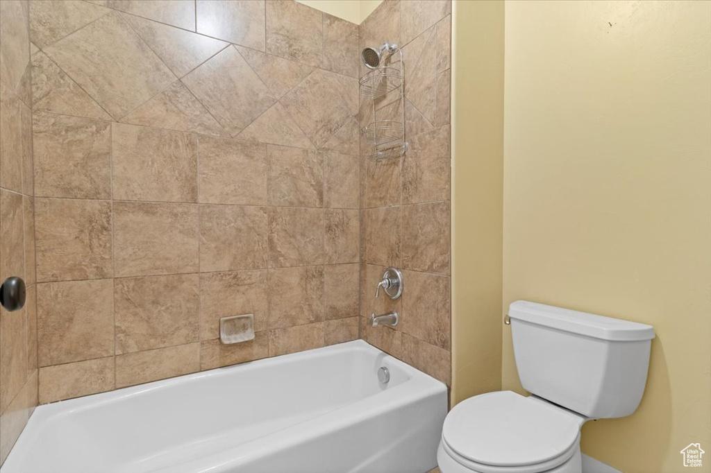Full bathroom featuring toilet, shower / washtub combination, and baseboards