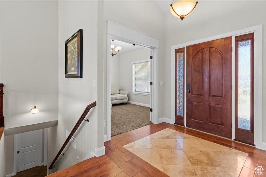Entryway with hardwood / wood-style flooring, baseboards, and a chandelier