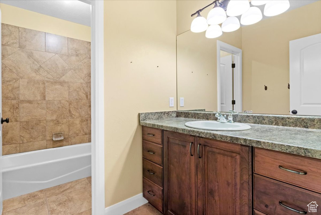 Full bathroom featuring vanity, tub / shower combination, tile patterned floors, and baseboards