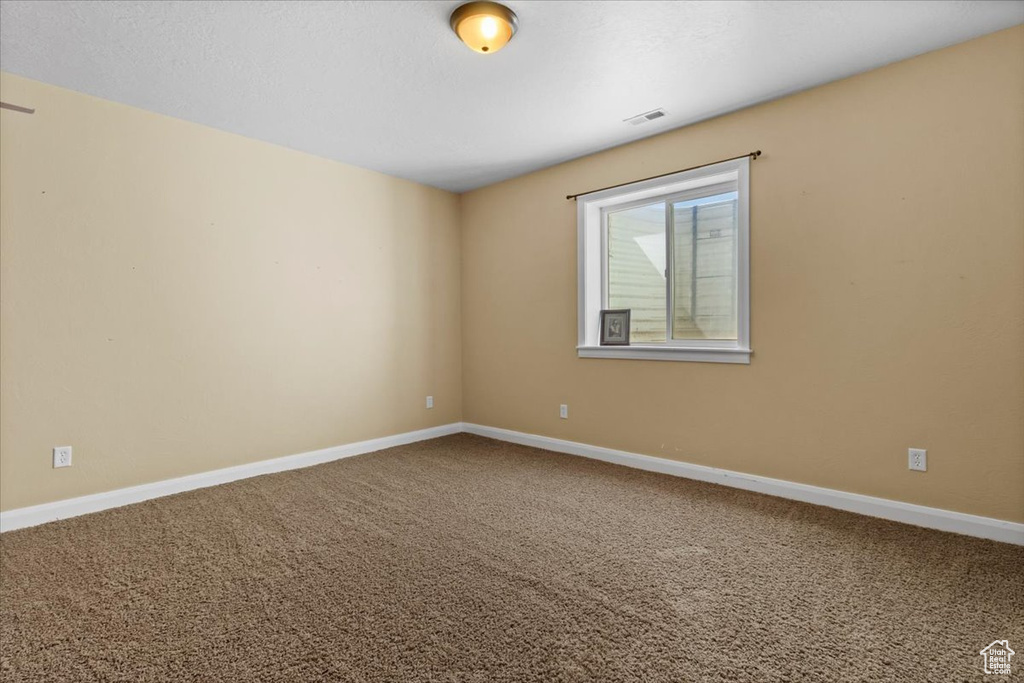 Carpeted empty room featuring baseboards