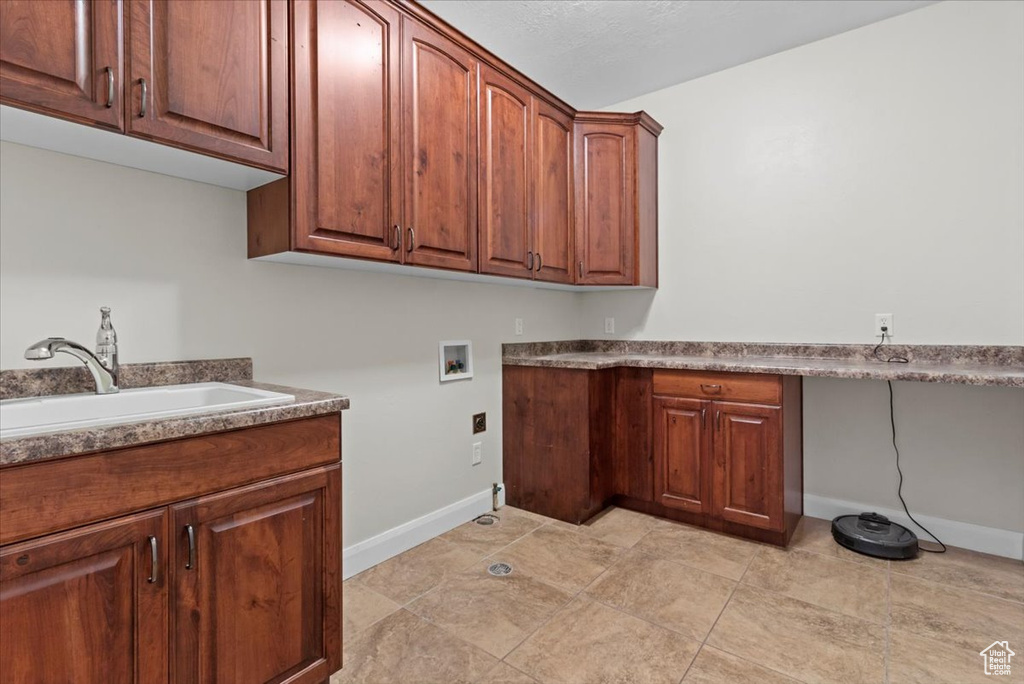 Laundry area featuring hookup for a washing machine, cabinet space, and baseboards