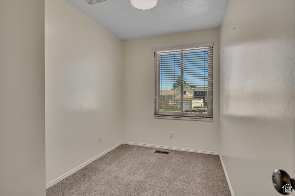 Carpeted empty room featuring baseboards