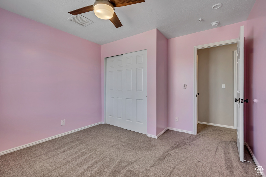 Unfurnished bedroom featuring carpet flooring, baseboards, and a ceiling fan