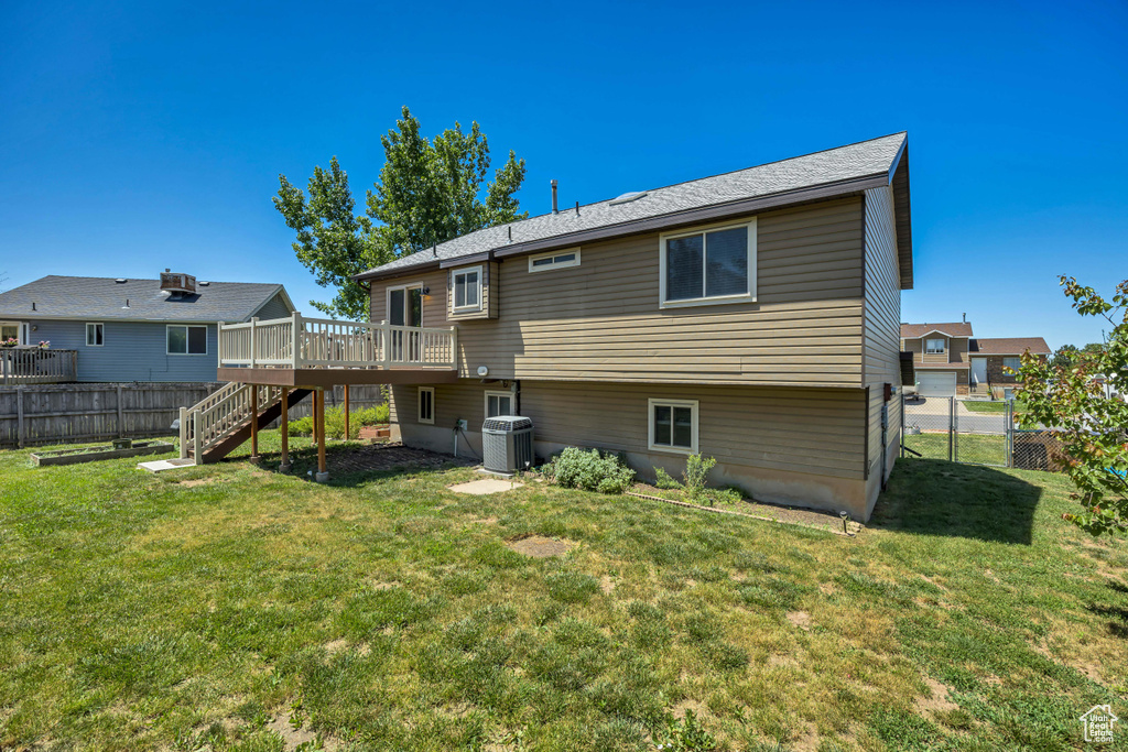 Rear view of house featuring a wooden deck, central AC, and stairway
