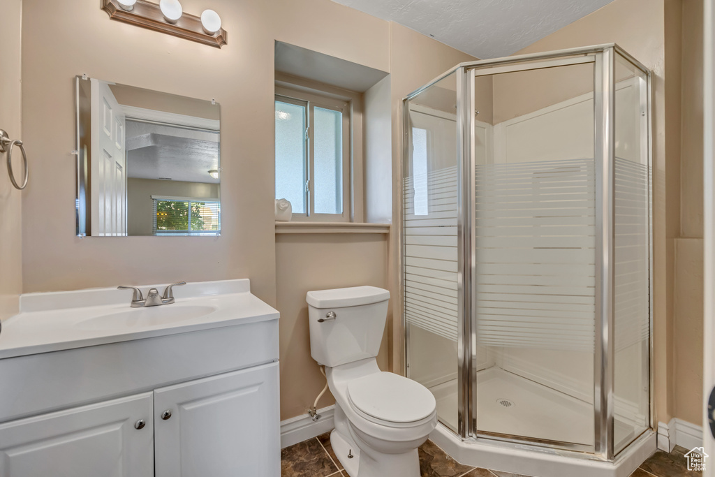 Bathroom with baseboards, a stall shower, vanity, and toilet