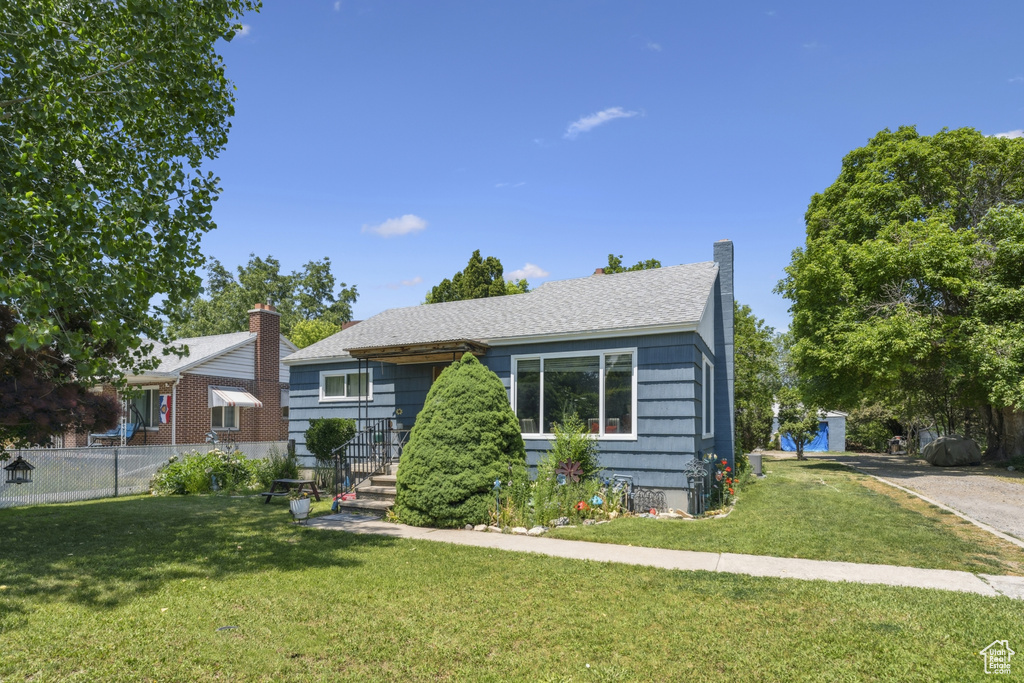 View of front of property featuring a shingled roof and a chimney