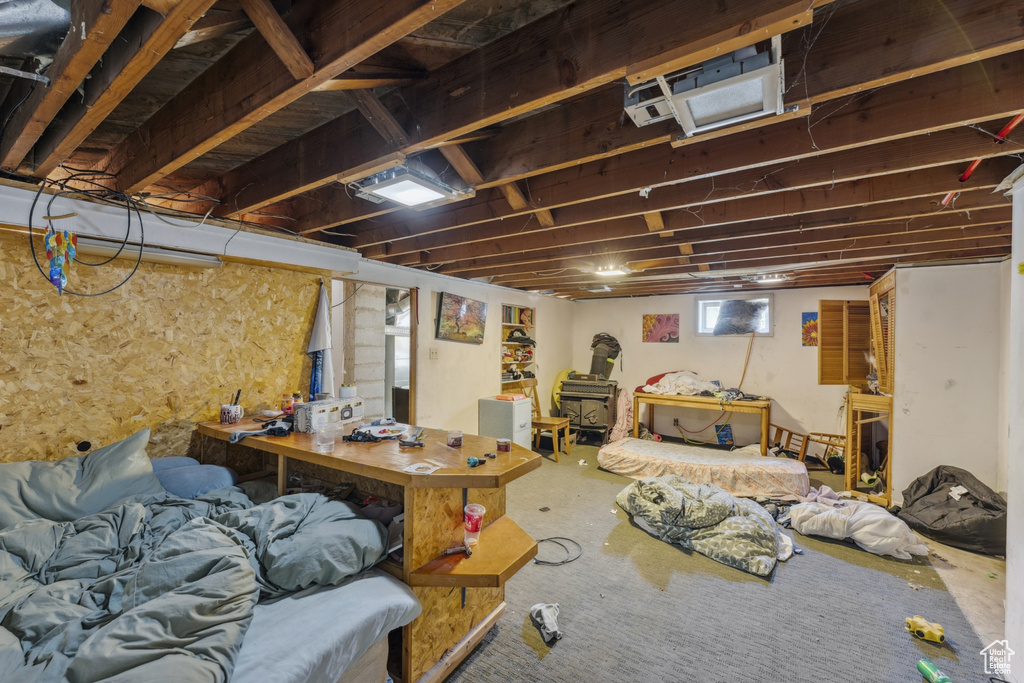 Basement featuring a wood stove and carpet
