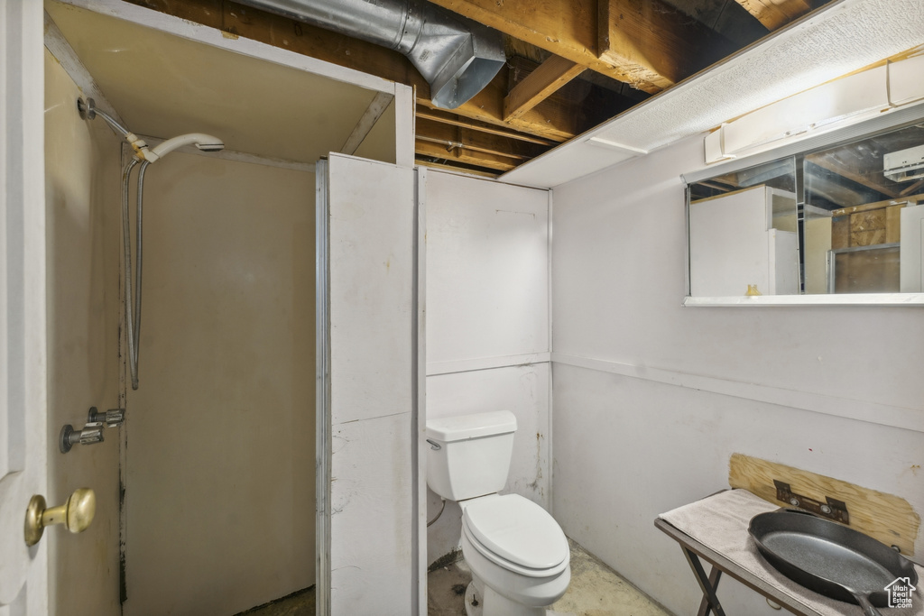 Bathroom with toilet and concrete flooring