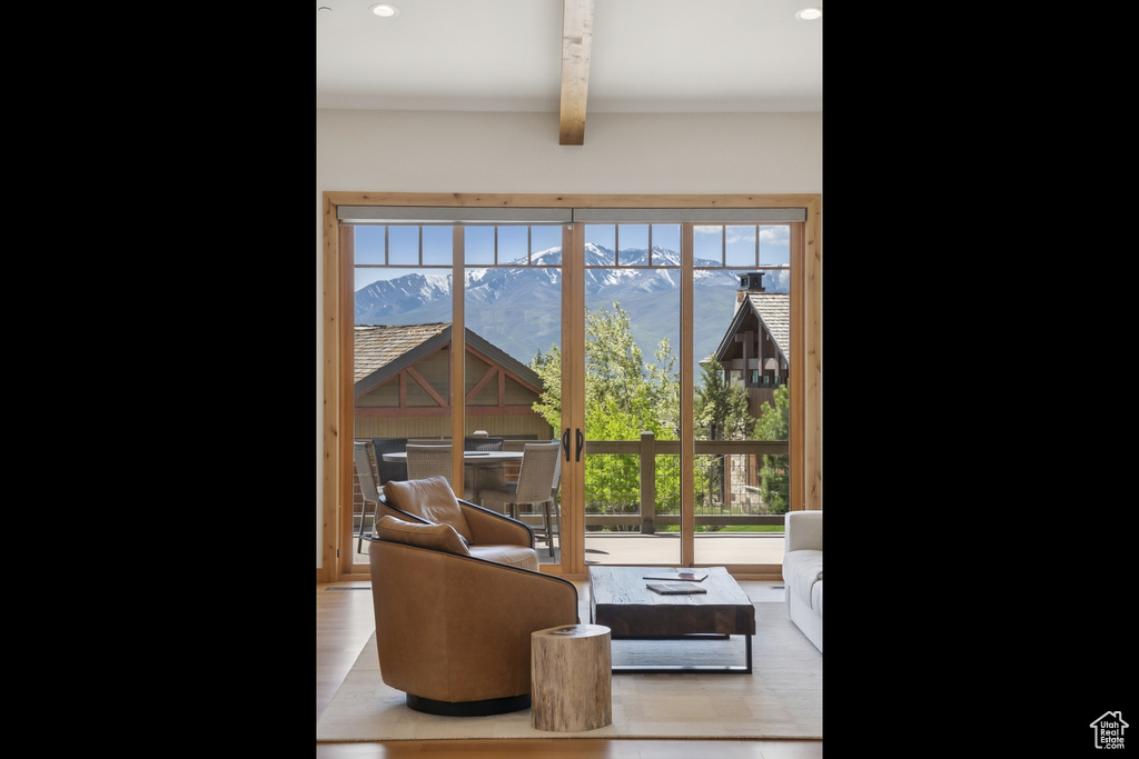 Living room with beamed ceiling and wood finished floors