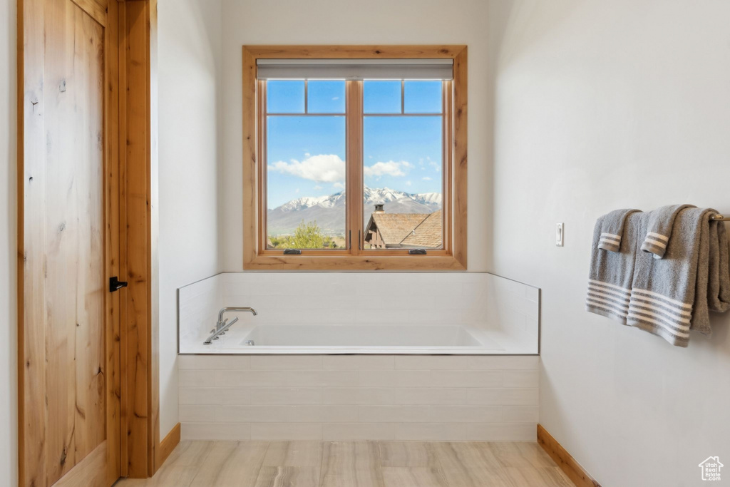 Bathroom with a garden tub and baseboards